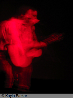 Kayla's photo of Alasdair Roberts playing the guitar and singing on stage at Norwich Arts Centre