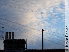 Kayla's photo of pale crescent moon in curdled clouds over May Terrace rooftop a minute or so later