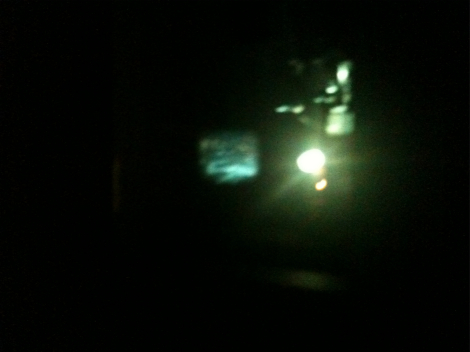 Kayla's photo of Luke Fowler's Flutter Screen installation in Peninsula Arts Gallery, view of 16mm projector and projected image on glass window in projection booth